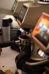 camarero rellenando café molido del dispensador de café en el mango del filtro de la cafetera del...