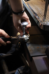 barista experto prensando café molido en el mango del filtro de la cafetera