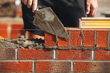 Bricklayer laying bricks on building site