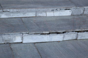 Old marble tiles on the city street. Repair of outdoor tiles.