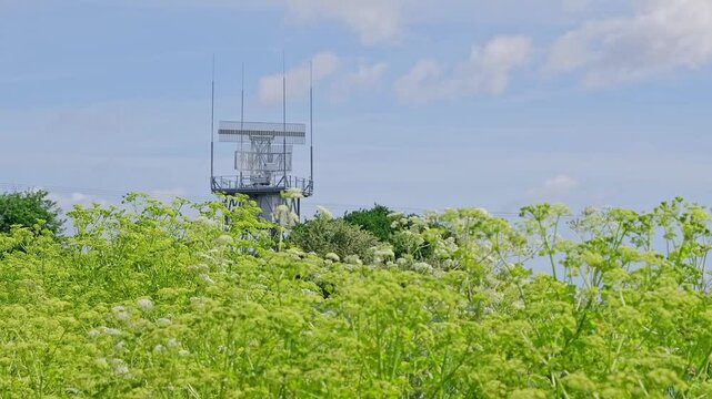 Rotating radar detector carrying out important surveillance on top of a tower in the countryside