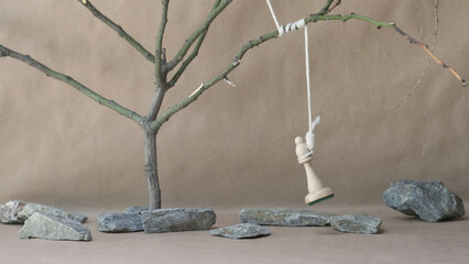 chess piece white bishop hanging on noose among stones