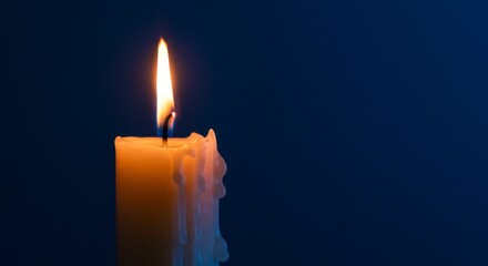 Fototapeta premium Solitary candle flame in tranquil atmosphere, symbol of hope and serenity
