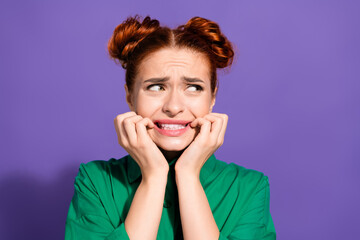 Portrait of a young stylish woman with red hair in a green shirt expressing concern against a...