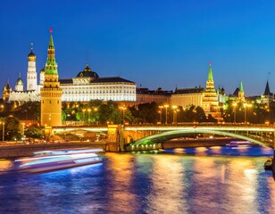 Fototapeta premium Moscow Kremlin at twilight. Panoramic view of Kremlin buildings, towers, and bridges over river. Night lights illuminate the structures. River traffic visible