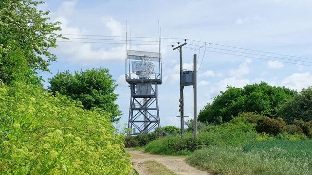 Rotating radar detector carrying out important surveillance on top of a tower in the countryside. Push in shot