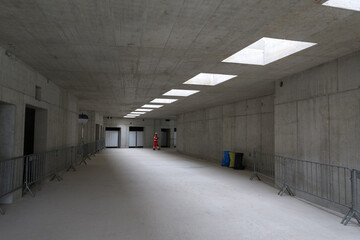 construction worker standing in a concrete hall with skylights