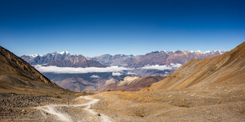 On the way from the Thorang La pass to Muktinath in front of a mountain range. Annapurna Circuit Trek, Nepal