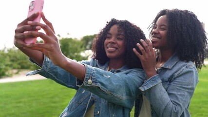 Twin sisters taking a selfie in the park - Powered by Adobe