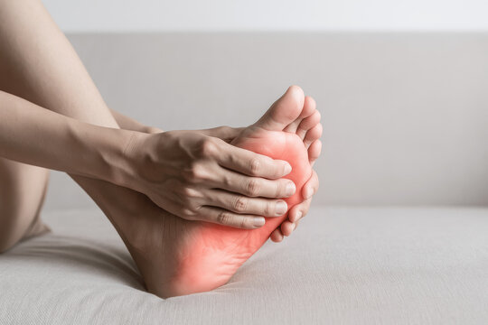 Close-Up of Woman Holding Her Foot in Pain with Red Highlight – Concept of Foot Injury, Plantar Fasciitis, or Foot Discomfort