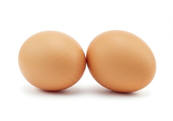 Two brown eggs side by side on a white background, illuminated with soft light in a simple composition