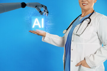 Robot hand and doctor with virtual AI microchip against blue background, closeup. Artificial...