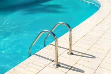 ladder stainless handrails stairs into the swimming pool concept blue water and sunlight blik of sun vacation relax healthy lifestyle sport concept havuz