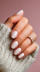 Fototapeta premium Elegant Manicure With White and Nude Nails Adorned With a Delicate Ring in a Cozy Setting