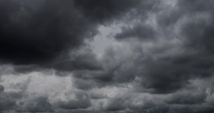 Dense black clouds covered the sky and are flying. Weather change to storm and hurricane with rain.