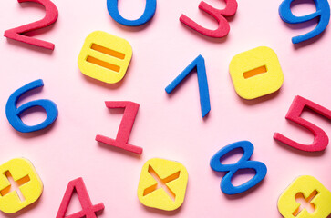 Fototapeta premium Colorful foam numbers and math symbols on pink background.