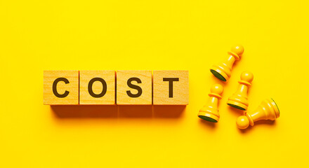 Cost spelled out with wooden blocks and white chess pawns on a yellow background flat lay view