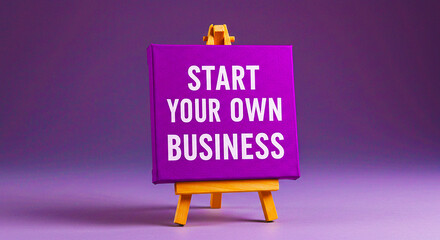 A purple canvas on a small wooden easel with the words start your own business in white lettering
