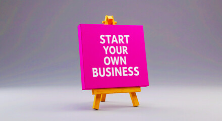 A pink canvas with start your own business text on a wooden easel against a gray background studio shot