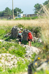selective focus of two pilgrims making the Way of St. James along the coast from Portugal