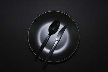 empty plate with cutlery set together on black background closeup shot , Flat lay food concept...