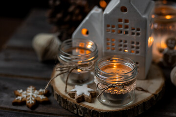Aromatic christmas handmade candle with the sweet scent of gingerbread cookies. Cozy holiday home atmosphere, aromatherapy. Interior composition with burning candles, anise, cinnamon, pine cones