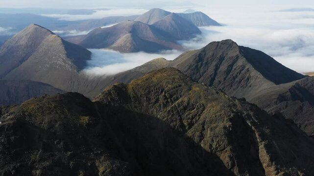 Cloud inversion over the rugged mountains on the Isle of Skye as hiker reaches the summit of Bla Bheinn - Views of to the Black Cuillin Ridge and the Red Cuillin Hills
