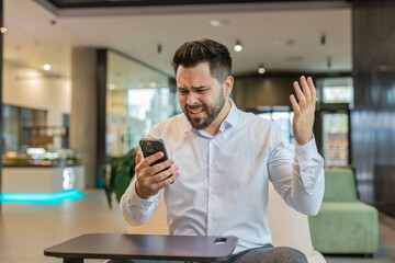 Businessman in formal shirt using smartphone typing browsing, loses becoming surprised sudden...
