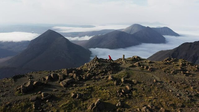 Cloud inversion over the rugged mountains on the Isle of Skye as hiker reaches the summit of Bla Bheinn - Views of to the Black Cuillin Ridge and the Red Cuillin Hills