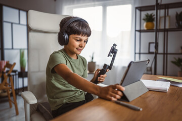 Child boy holding gimbal and live streaming at home,
