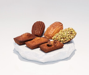 Elegant French Madeleines and Financiers on White Marble Plate in a Premium Dessert Cafe