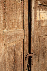Old wooden locked brown house door.