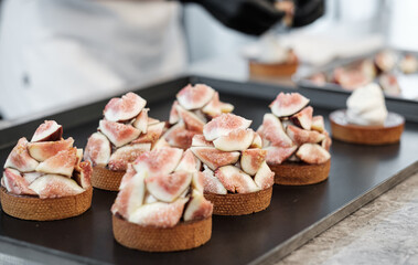 Fresh Fig Tarts Being Assembled by a Pastry Chef in a Gourmet Cafe