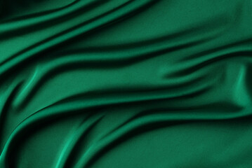 Abstract dark emerald green background. Green silk satin fabric with soft wavy folds. Elegant...
