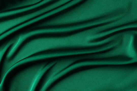 Fototapeta Abstract dark emerald green background. Green silk satin fabric with soft wavy folds. Elegant background with space for text. Christmas or New Year table