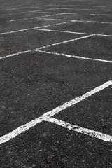 Perspective View Of An Empty Asphalt Parking Lot With Faded White Painted Lines Marking Parking...
