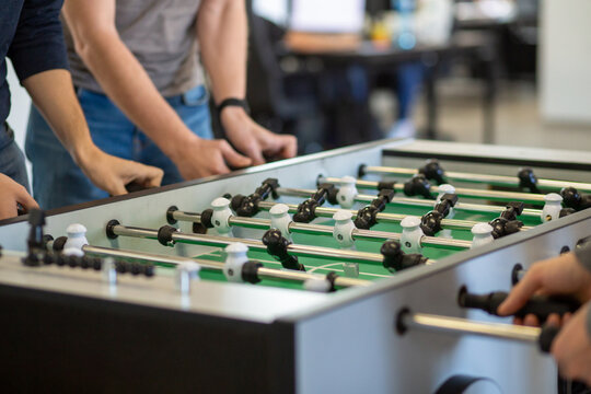 Group playing foosball in office break area