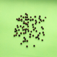 Piper nigrum - Black peppercorns on green background