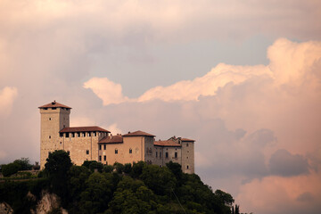 Fototapeta premium Historic Castle Surrounded by Lush Landscape Under a Dramatic Sky
