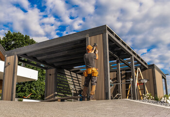Craftsman Constructs a Modern Outdoor Structure on a Sunny Day Amid Fluffy Clouds in a Residential...