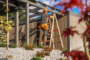 Construction Worker Climbs Ladder to Work on Modern Building in Sunny Outdoor Setting