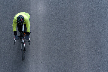 Cyclist on the road, top view - obrazy, fototapety, plakaty