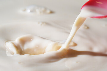 Close up shot of splashing fresh milk on container