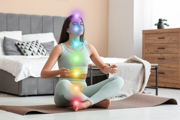 Beautiful young woman doing breath practice on yoga mat at home
