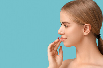 Young woman with beautiful lips on blue background