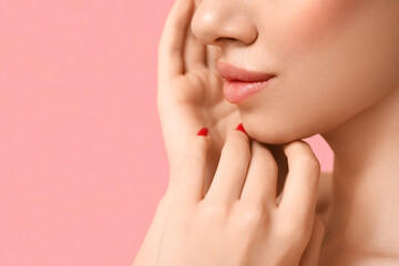 Young woman with beautiful lips on pink background, closeup