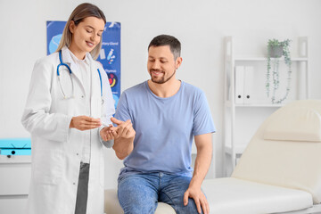 Fototapeta premium Female endocrinologist measuring blood sugar level of man in clinic