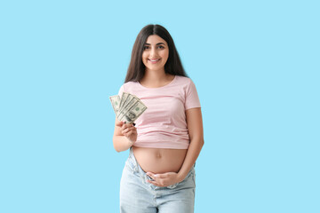 Young pregnant woman with dollar banknotes on blue background. Maternal Benefit concept