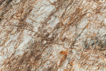Closeup of textured stone surface with natural brown and white patterns