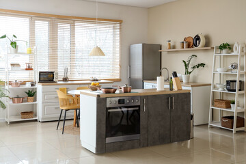 Interior of kitchen with counters, shelf units and dining table